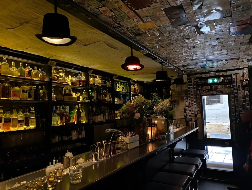 Le comptoir du Code Bar sous son plafond couvert de billets
